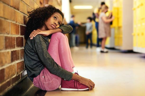 kid sitting on floor, school hallway